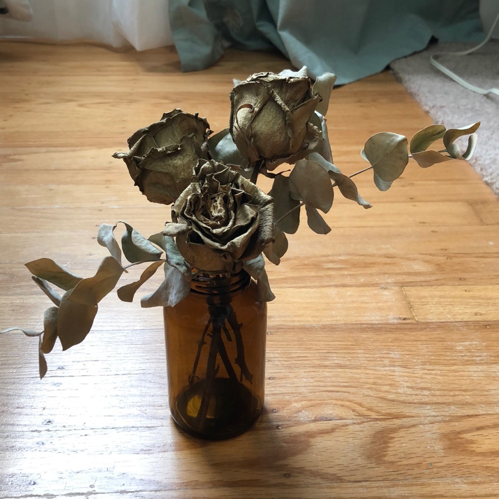 Dried floral arrangement in amber vintage jar
